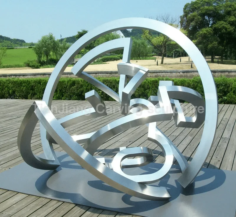 534d4e46-8c9e-48e8-ad35-6e258eba8837.webp Brushed stainless steel abstract circular interwoven sculpture