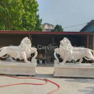 Off-white marble European-style walking lion sculptures (pair)